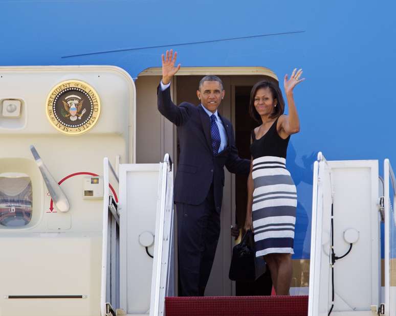 Obama e Michelle abanam antes de entrar no Air Force One, na base aérea Andrews
