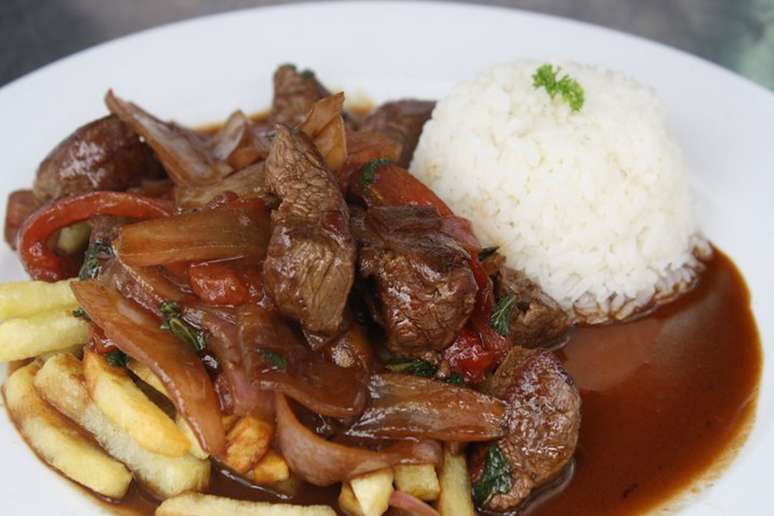 <p><strong>Lomo saltado</strong><br />Outro tradicional prato peruano, o lomo saltado, traz um toque da influência da imigração oriental. A carne de vaca, cortada em finas tiras, é preparada com molho shoyu, tomate, cebola e temperos. Normalmente a carne é servida com algum tipo de batata ou tacu tacu</p>