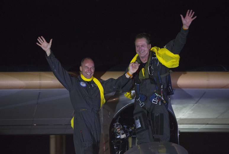 Bertrand Piccard e Andre Borschberg (dir.) acena após o pouso do avião Solar Impulse