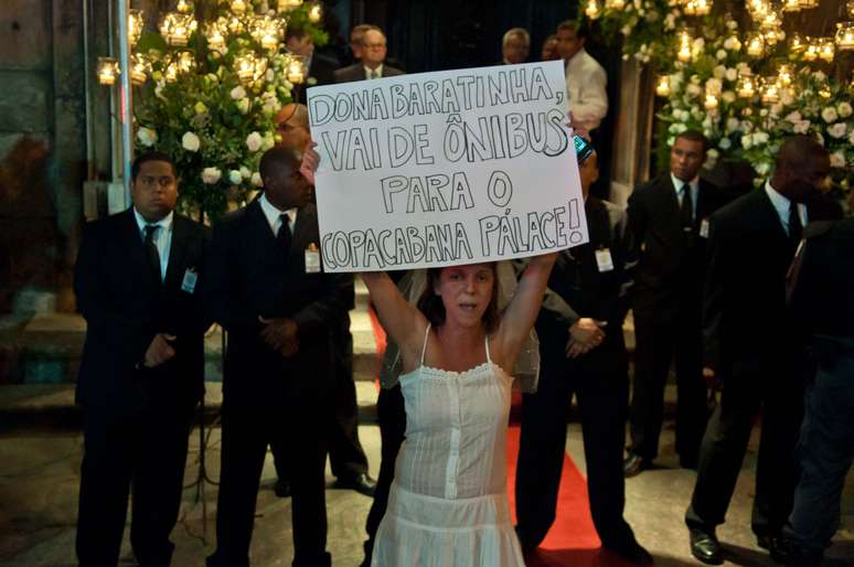 <p>Seguranças observam manifestante vestida de noiva em frente à Igreja do Carmo, no Rio</p>