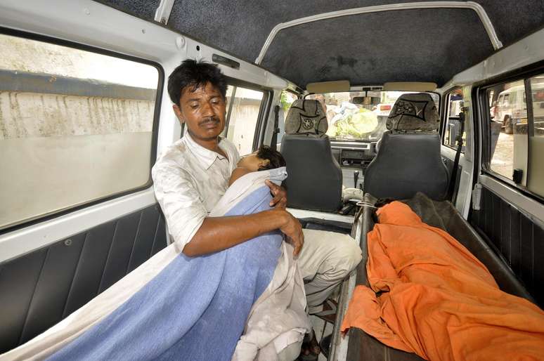 Homem abraça criança contaminada a caminho do hospital em Chapra
