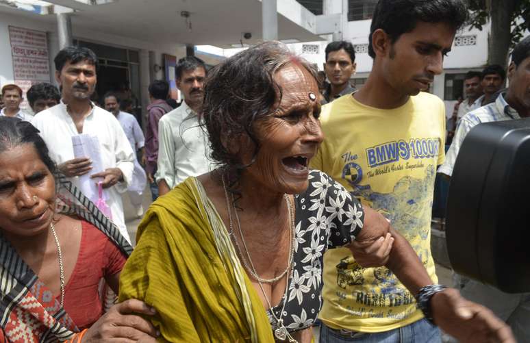 Mulher chora após receber a confirmação de que seu neto morreu após ingerir a refeição contaminada