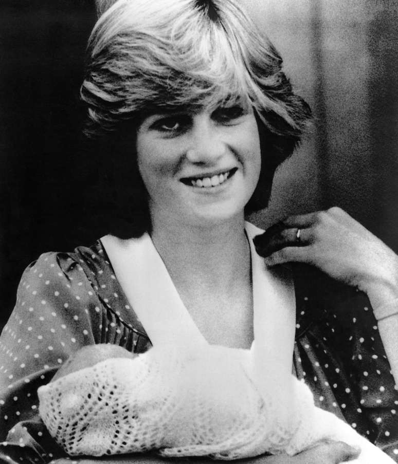 <p>A princesa Diana posou para os fotógrafos saindo da maternidade pós-nascimento do príncipe William, em 1982; o bebê estava usando uma mantinha clara</p>