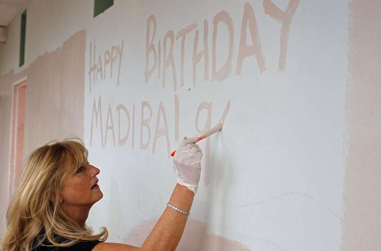 Mulher pinta mural em homenagem ao aniversário de Mandela na Cidade do Cabo. A data também é celebrada pelos brancos sul-africanos