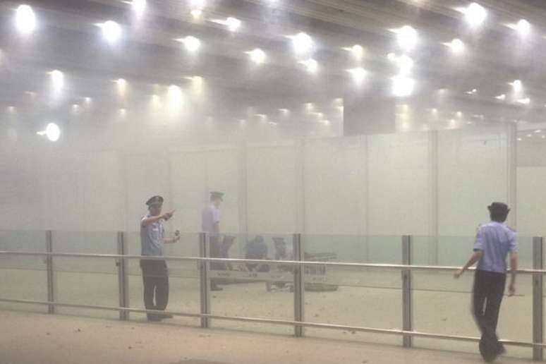 Policiais trabalham em meio à fumaça após explosão de bomba em aeroporto na China