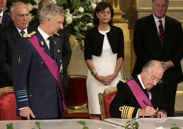 Observado pelo filho, rei Albert II assina o ato de abdicação no Palácio Real