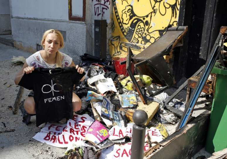 Líder do Femen, Inna Shevshenko, mostra o que restou de seus pertences após incêndio