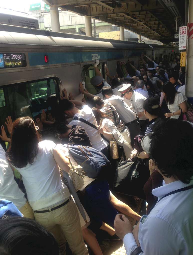 Imagem mostra os passageiros empurrando o vagão para salvar a mulher que caiu no vão