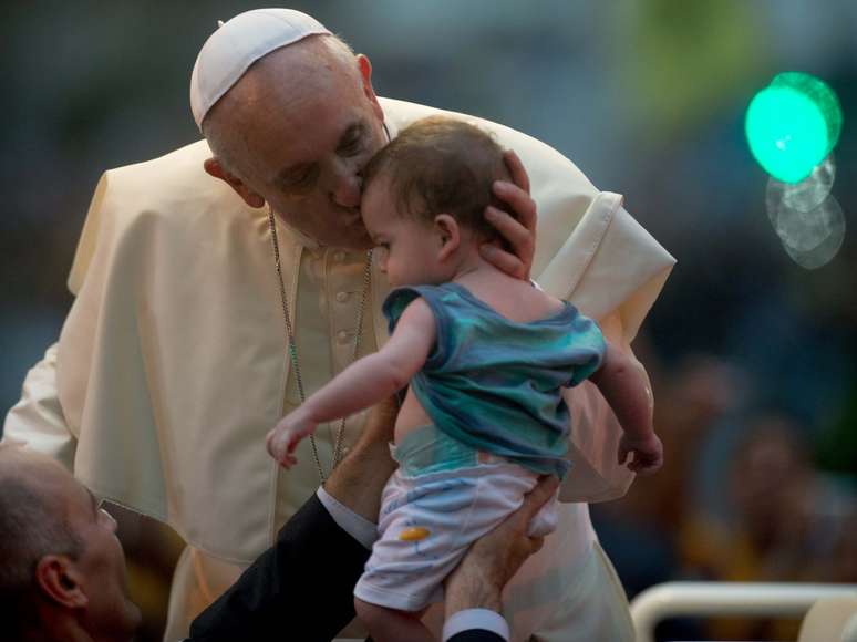 Papa Francisco beija criança entregue durante desfile pelas ruas do Rio de Janeiro