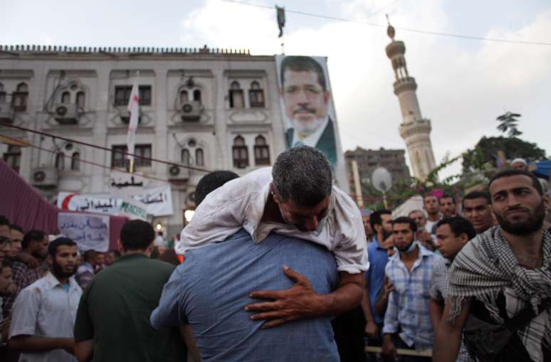 Simpatizantes de Mursi carregam colega ferido durante o confronto