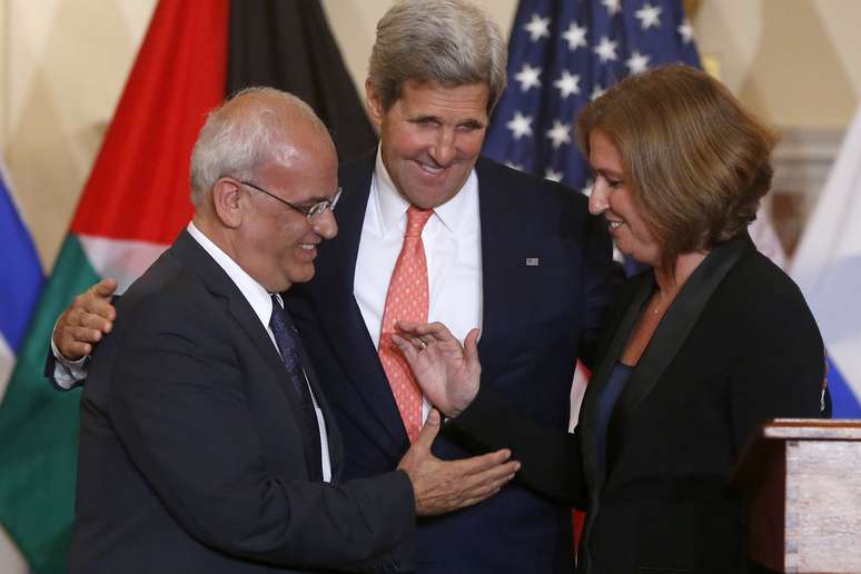 John Kerry promove cumprimento entre a ministra israelense Tzipi Livini (dir.) e o negociador palestino Saeb Erekat, em Washington