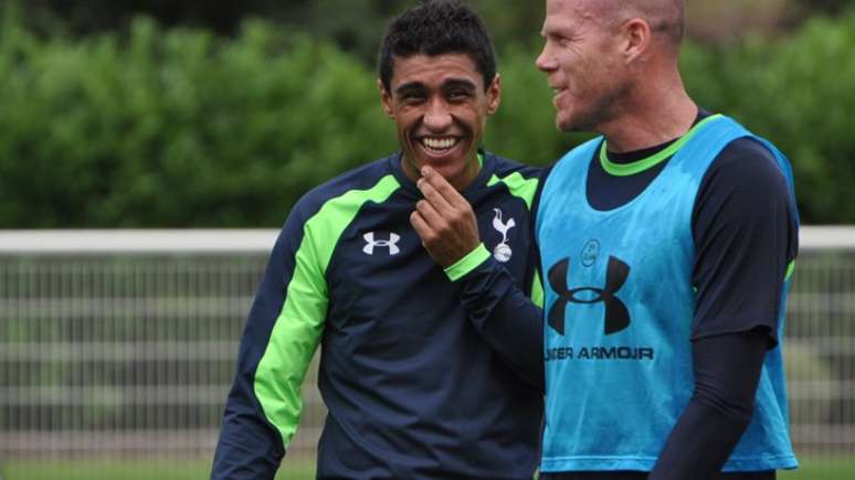<p>Paulinho ri ao lado do veterano goleiro Brad Friedel durante seu primeiro treino no Tottenham</p>