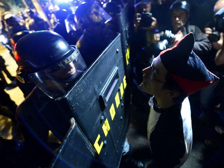 <p><strong>30 de julho</strong> - Manifestante encara policial</p>
