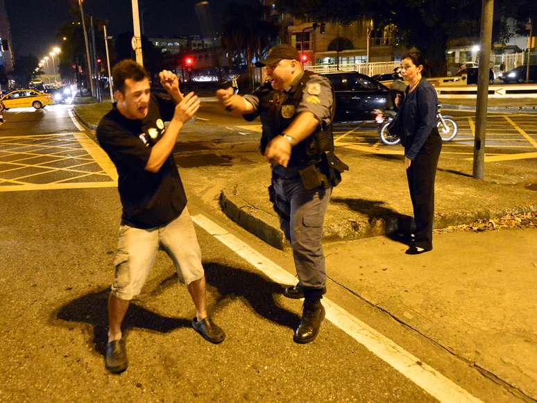 <p>Homem tenta se proteger de policial durante protesto contra a Rede Globo no Rio de Janeiro</p>