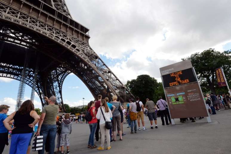 Turistas aguardam na base da Torre Eiffel, evacuada após ameaça