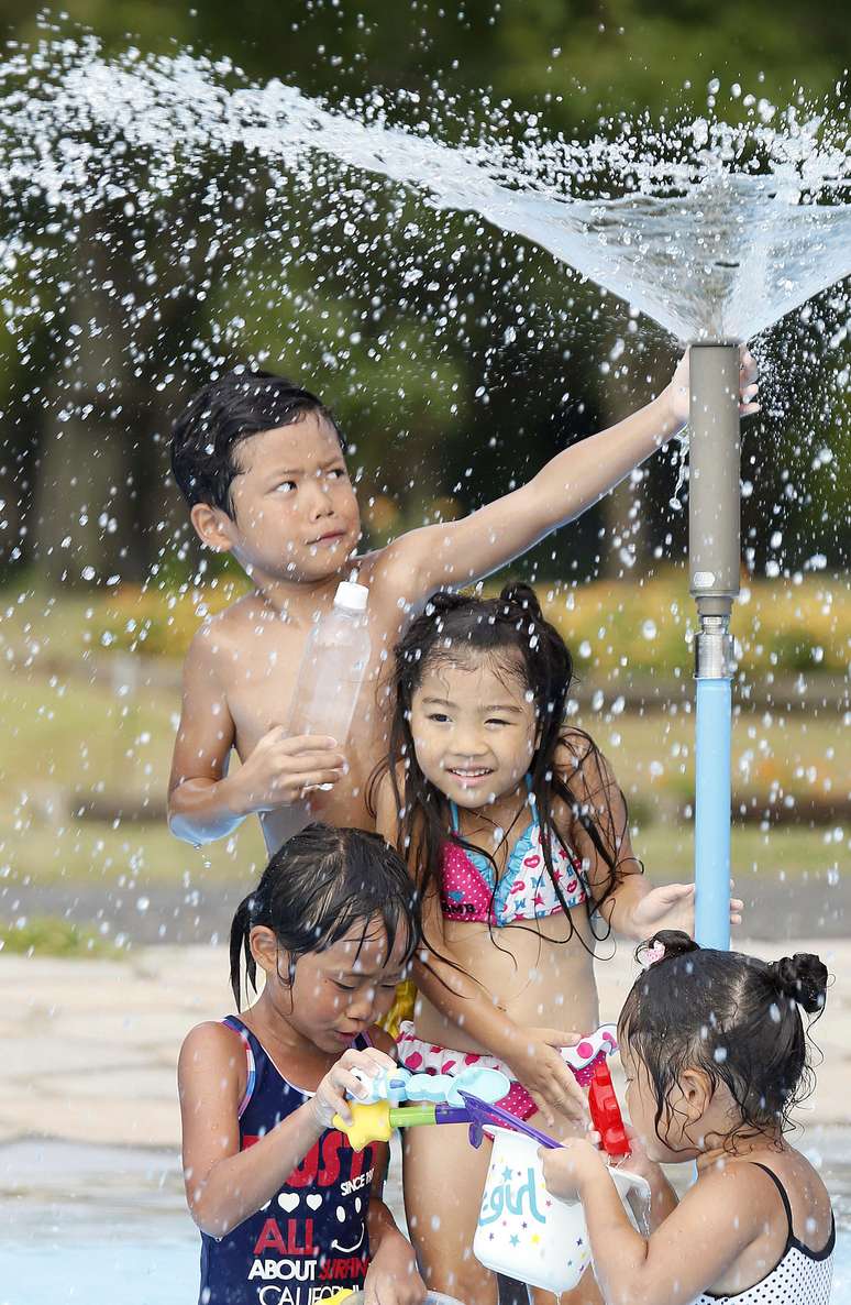 <p>Crian&ccedil;as brincam em uma fonte em Kumagaya, perto de T&oacute;quio, em um dia de calor de 40&deg;C</p>