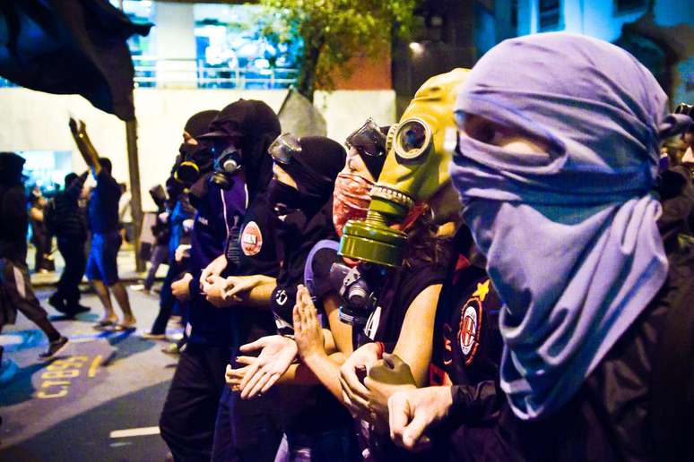 <p>Mascarados, manifestantes marcham por ruas do centro do Rio de Janeiro</p>