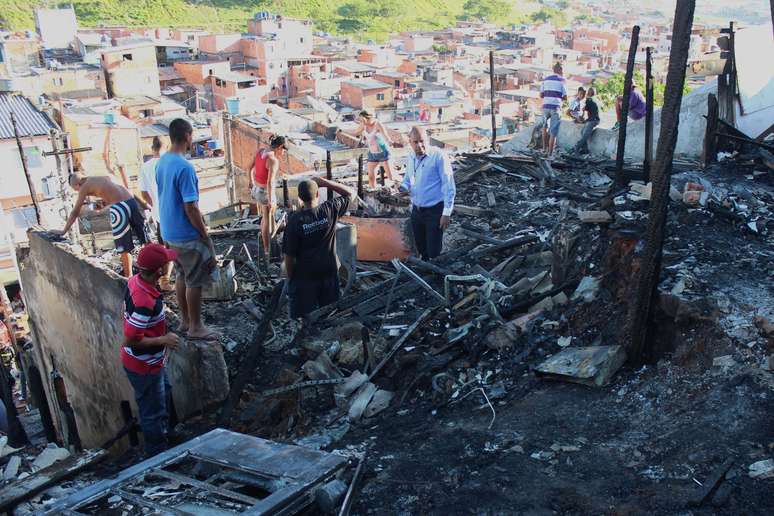 Moradores vasculham entulho atrás de pertences perdidos no incêndio