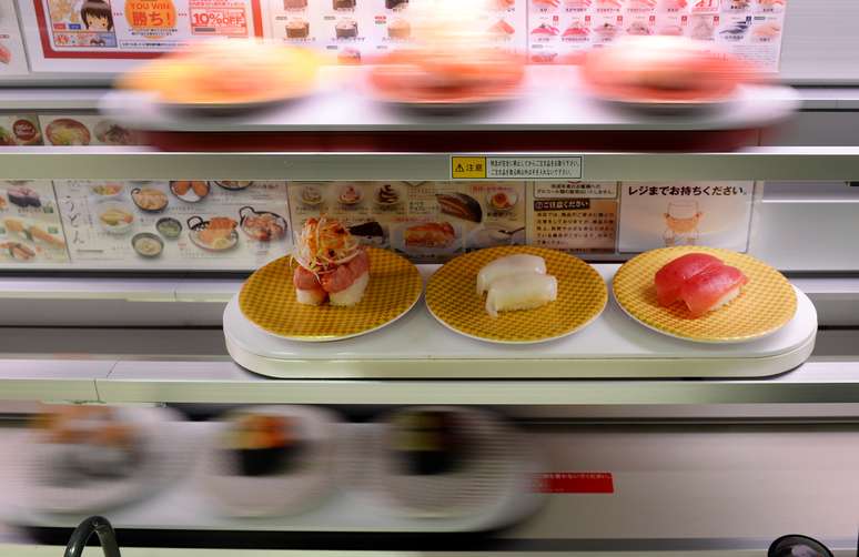 Balcões com três decks de raias de alta velocidade fornecem sushi diretamente à pessoa que fez o pedido em uma tela sensível ao toque multilínguas