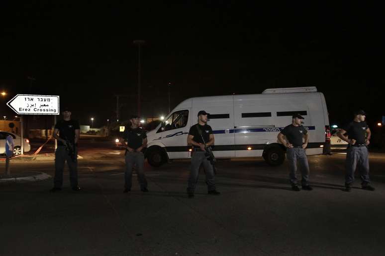 Policiais israelenses protegem veículo que leva prisioneiros palestinos durante a passagem para Gaza