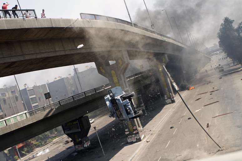 Manifestantes atiram viatura da polícia de ponte no Cairo em protesto contra a ação da polícia