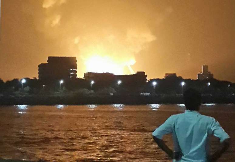Homem observa a embarcação em chamas, em Mumbai