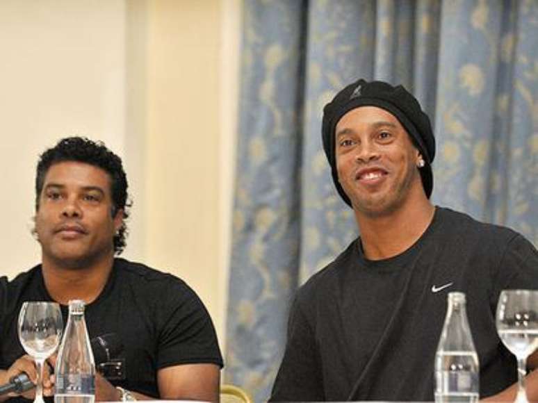 Assis ao lado do irmão, Ronaldinho, que atua no Atlético-MG