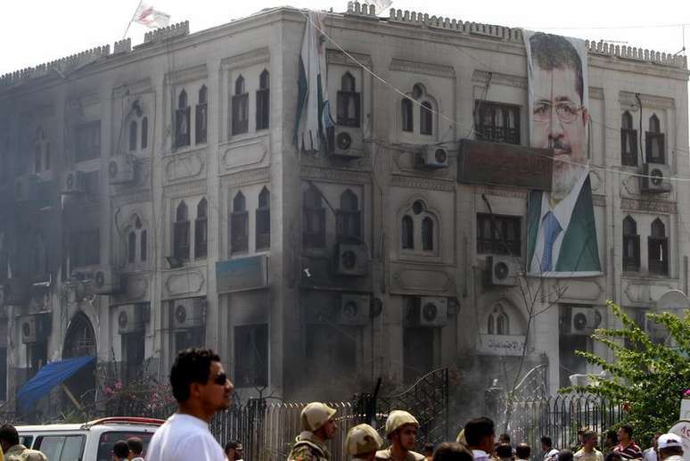 <p>Cartaz de Mursi pendurado sobre um prédio anexo à mesquita Rabaa Adawiya que foi incediado após a dispersão de um acampamento</p>