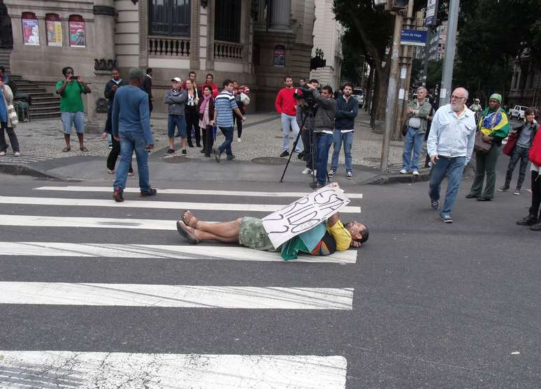 <p>Com cartaz, manifestante se deita na faixa de pedestres em frente à Câmara e protesta: "onde está o Amarildo?"</p>