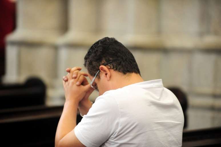 Homem reza durante missa na Catedral da Sé