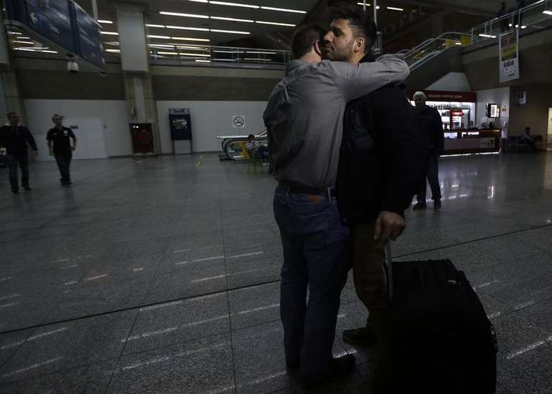 Jornalista Glenn Greenwald abraça seu companheiro, David Miranda, em sua chegada ao aeroporto internacional do Rio de Janeiro. O governo britânico defendeu nesta terça-feira a detenção, baseada na lei antiterrorismo, do companheiro brasileiro do jornalista que denunciou os programas secretos de vigilância britânico e dos EUA com base em vazamentos de Edward Snowden, alegando que o Estado tem o dever de "proteger o público". 19/08/2013.