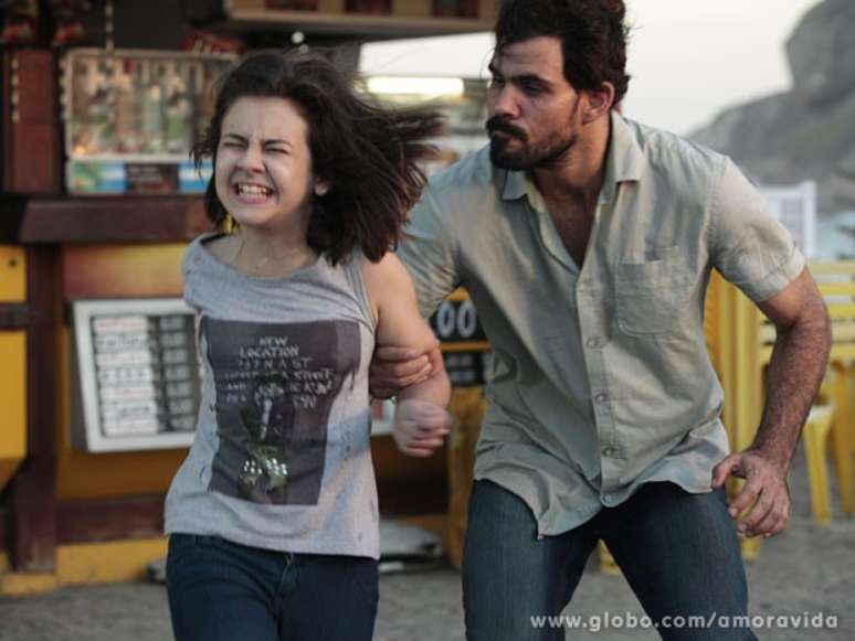 Paulinha (Klara Castanho) tenta correr e pedir ajuda na praia, mas é pega por Ninho (Juliano Cazarré)