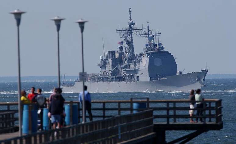<p>Turistas observam o navio de guerra cruzador de mísseis USS Mahan partindo para o oceano Atlântico, perto de Virginia Beach, nos Estados Unidos, em setembro de 2003</p>