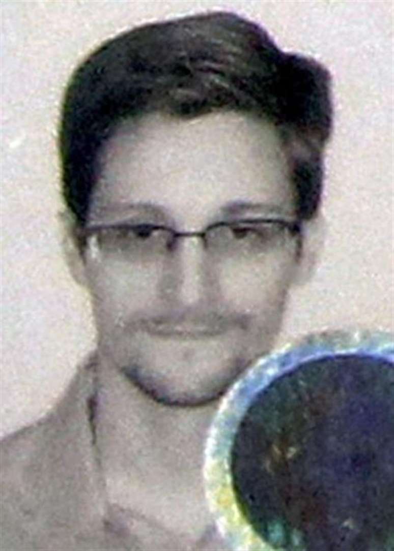 O ex-prestador de serviços de uma agência espiã dos EUA Edward Snowden é visto neste retrato estampado em seus documentos de refugiado, concedidos pela Rússia, nesta fotografia tirada durante uma coletiva de imprensa em Moscou. O presidente russo, Vladimir Putin, descreveu Snowden, procurado pelos EUA sob acusação de espionagem, como um "cara estranho", mas disse que ele pode descansar tranquilo pois não será entregue às autoridades norte-americanas. 1/08/2013.