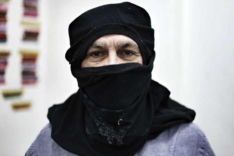 Caetano Veloso posa com o rosto coberto com uma camiseta, da mesma forma usada pelo grupo Black Bloc