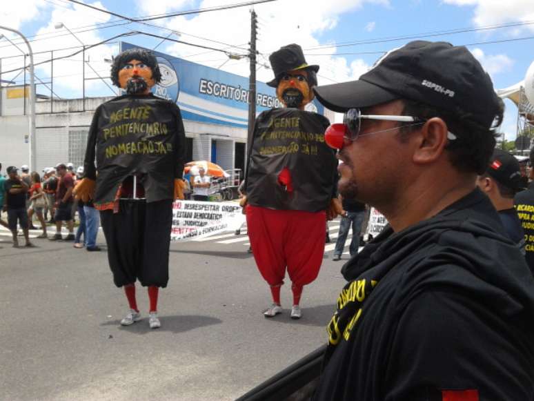 Grupo de aprovados no concurso para agentes penitenciários da Paraíba que não foram nomeados protestam. Cerca de 40 pessoas vestiram camisas pretas, narizes de palhaço, apitos e faixas para reivindicar a nomeação por parte do governo do Estado