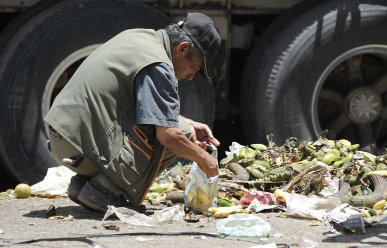 <p>Homem cata restos de comida em um mercado de Bogotá. Cerca de um terço dos alimentos para consumo, aproximadamente de 1,3 bilhão de toneladas, é desperdiçado </p>