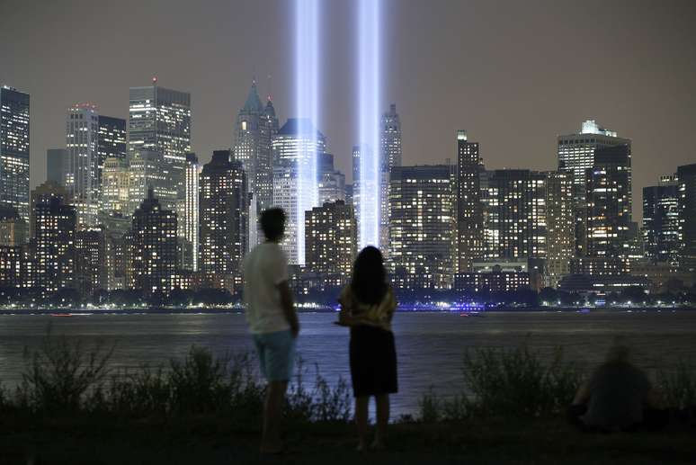 Casal observa a homenagem às margens do rio Hudson