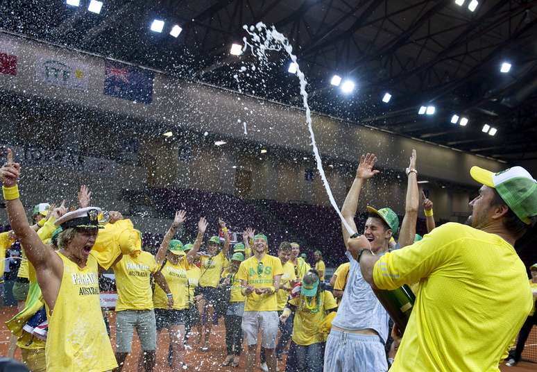 <p>Capit&atilde;o australiano, ex-jogador Patrick Rafter abre o champagne para comemora a conquista da vaga no Grupo Mundial</p>