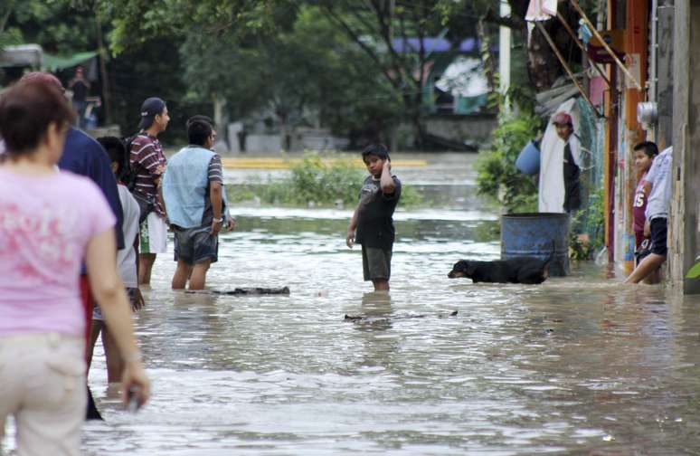 Moradores percorrem uma rua inundada em Poza Rica, no estado mexicano de Veracruz