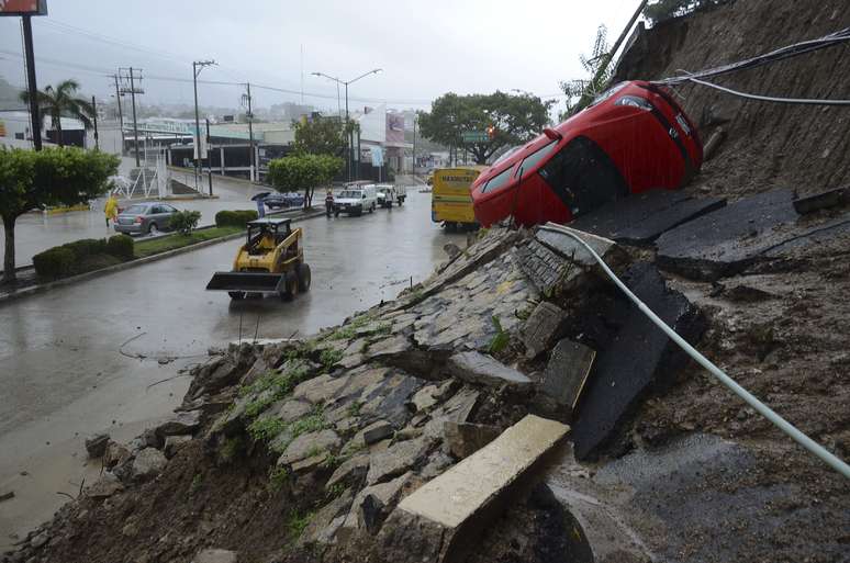 Carro é visto virado de lado após colina desabar após fortes chuvas em Acapulco