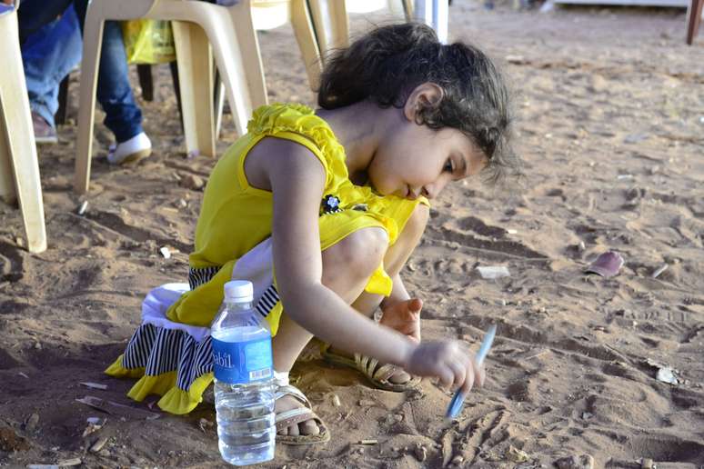 Criança brinca enquanto família é cadastrada como refugiados da Síria