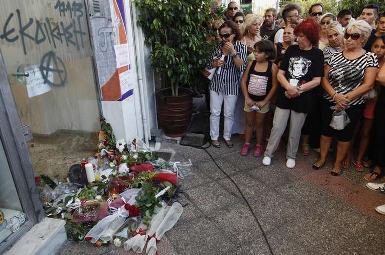 Pessoas se aglomeram no local em que Pavlos Fissas, um rapper de 35 anos, foi esfaqueado até a morte por um ativista de extrema direita, em Atenas. A morte de Fissas, de 34 anos, motivou manifestações populares em várias cidades, com episódios de violência na quarta-feira à noite. 18/09/2013.