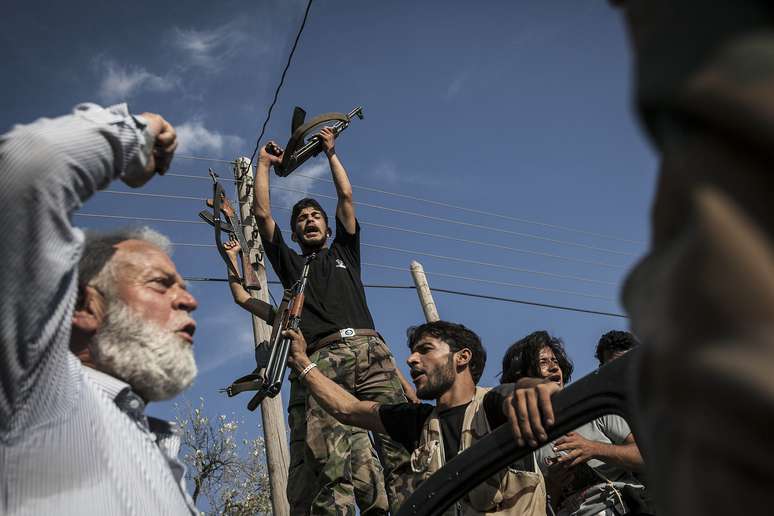 Combatentes sírios celebram no vilarejo de Kafr Nabuda