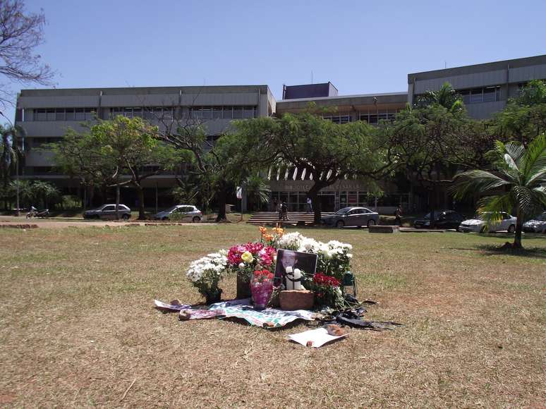 Vasos de flores, fotos, velas e uma flâmula do time do Palmeiras estão no gramado na Praça do Ciclo Baísico 2, onde o estudante Denis Casagrande recebeu os primeiros socorros