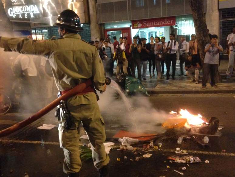 <p>Bombeiro apaga um dos vários focos de incêndio promovido pelos manifestantes durante protesto na terça-feira</p>