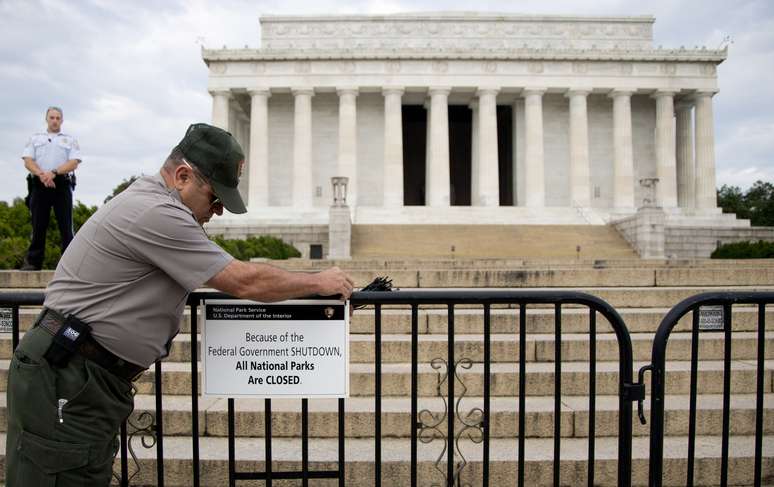 Policial ajusta placa que alerta sobre o fechamento do Lincoln Memorial, em Washington