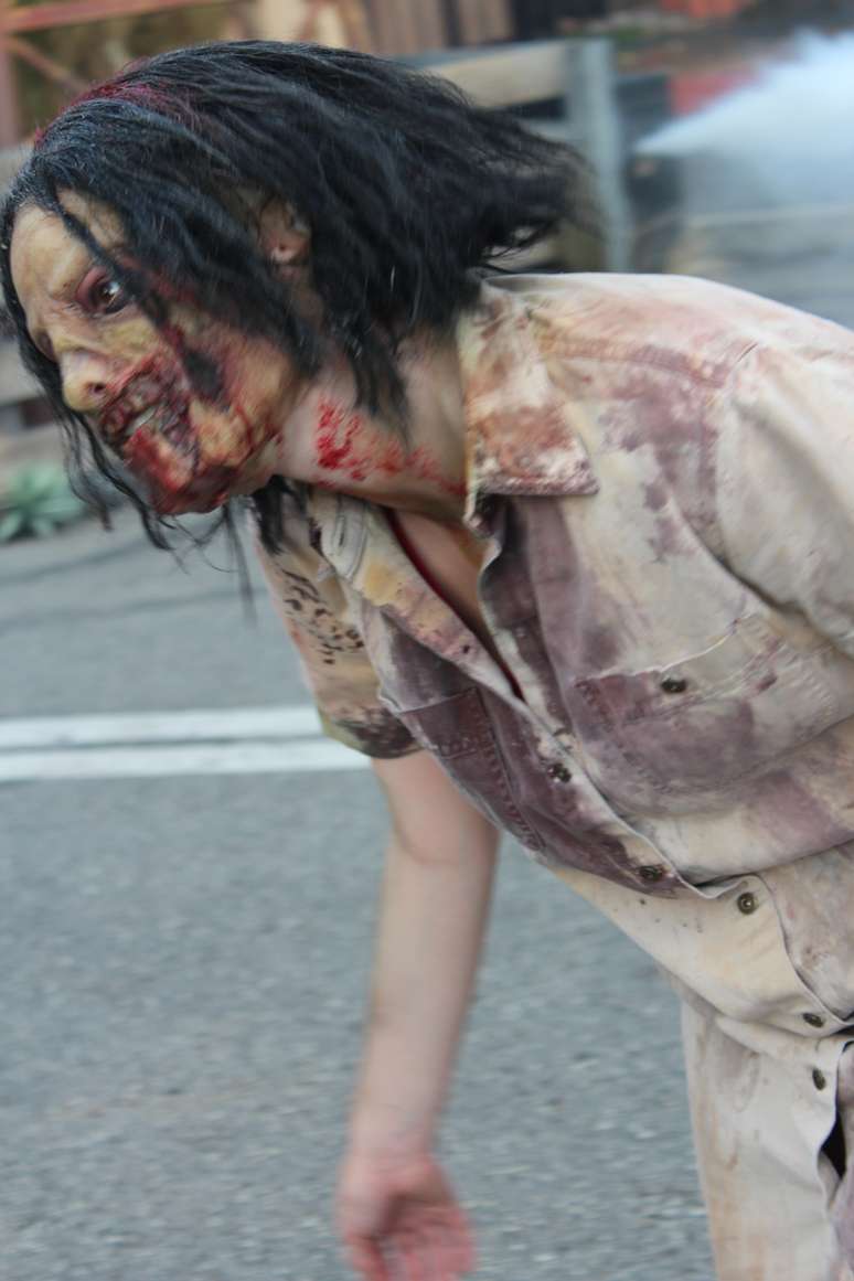 <p>Zumbis inspirados na série 'The Walking Dead' interagem com os turistas nas ruas do parque</p>
