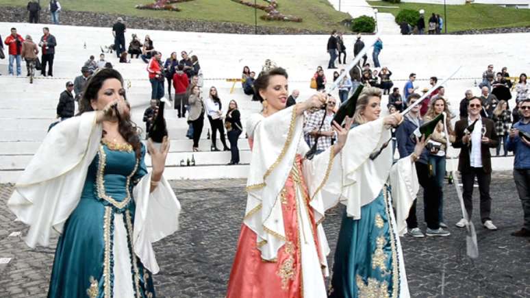 <p>Com trajes típicos, mulheres participam de sabrage coletivo na Festa do Espumante de Garibaldi, no Rio Grande do Sul</p>
