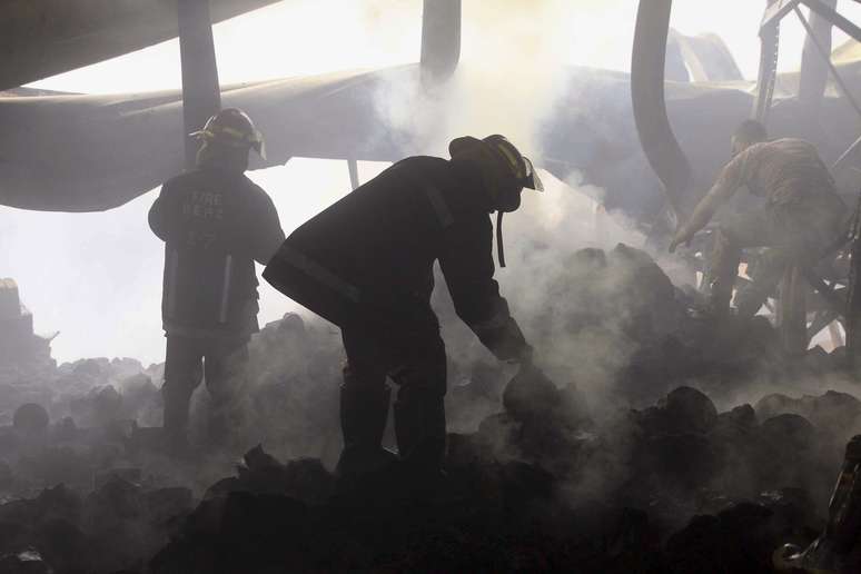 Bombeiros trabalham na fábrica após incêndio
